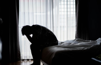 distraught man sitting on bed