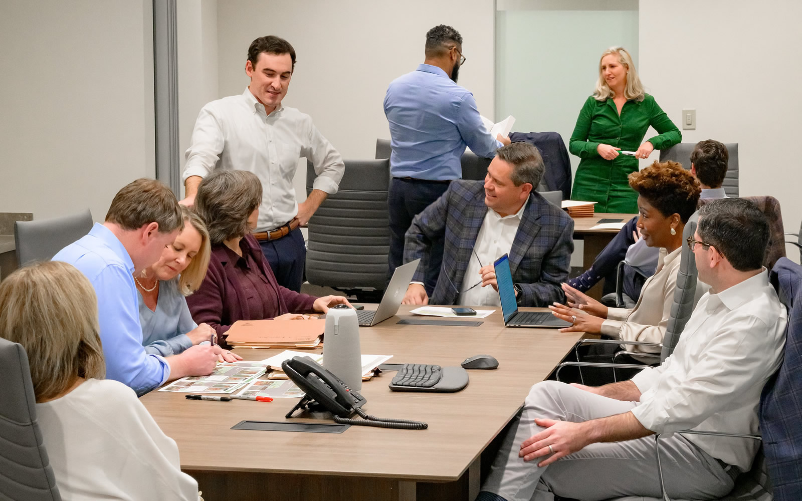 Collaborative meeting taking place in a bright and spacious conference room, featuring a diverse group of professionals.